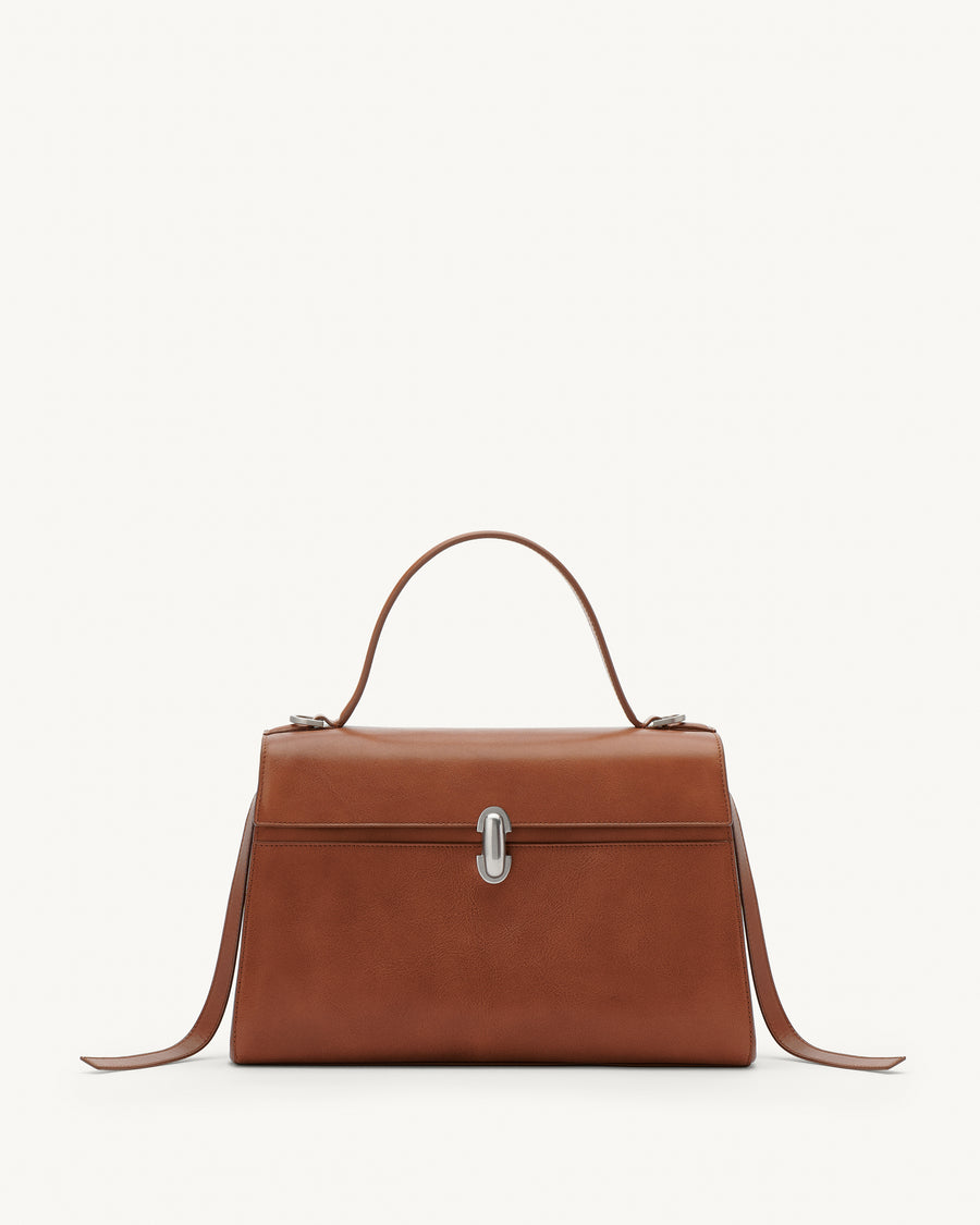 Front view of a cognac brown leather bag with a silver clasp on a white background 