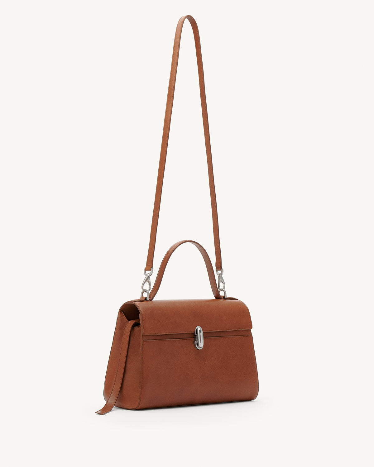 side view of a cognac brown leather bag with a silver clasp on a white background 
