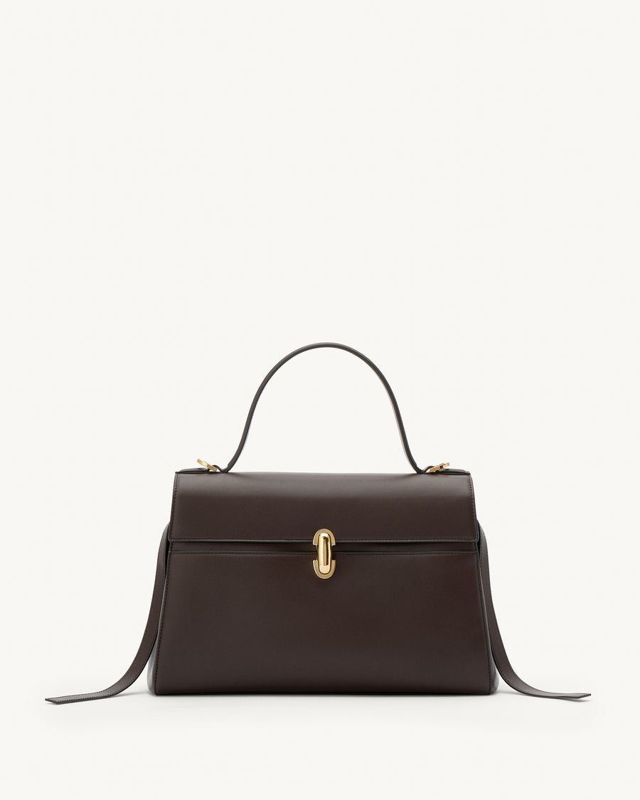 front view of a coffee brown leather bag with a gold clasp on a white background