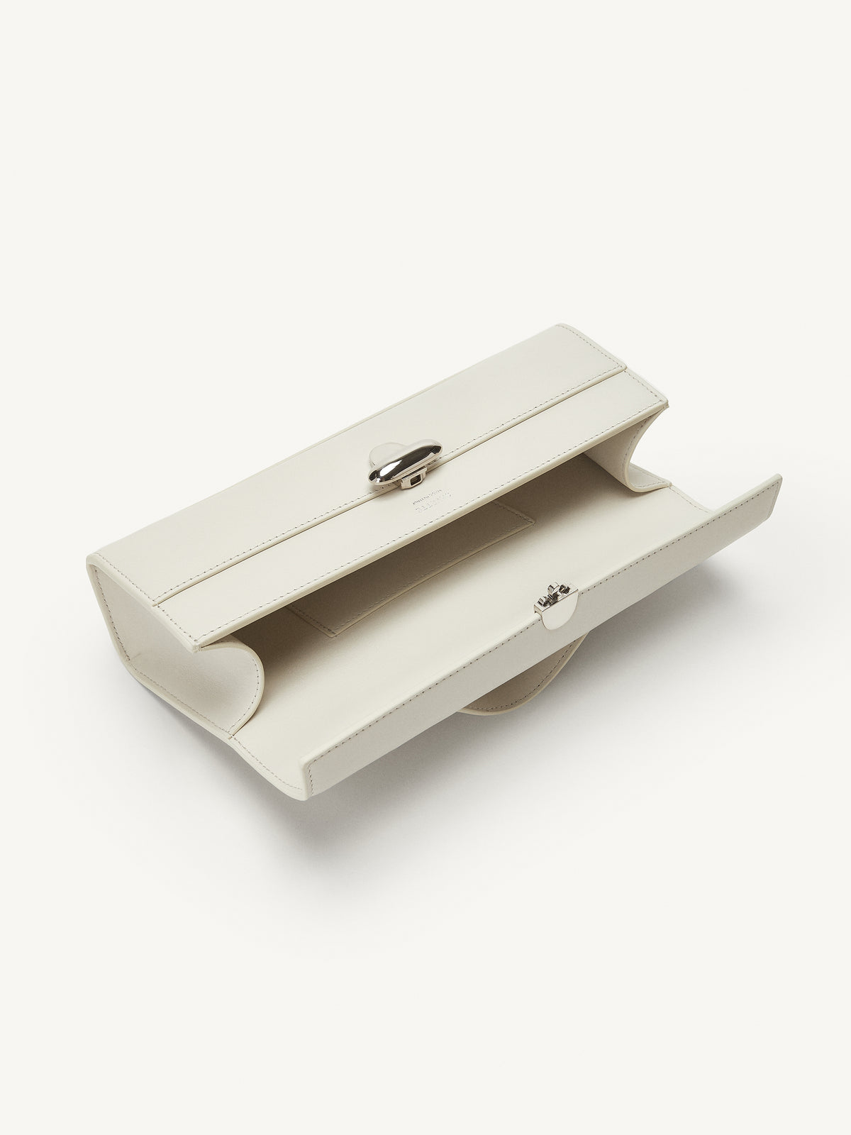 interior view of ivory bag with silver clasp on a white background