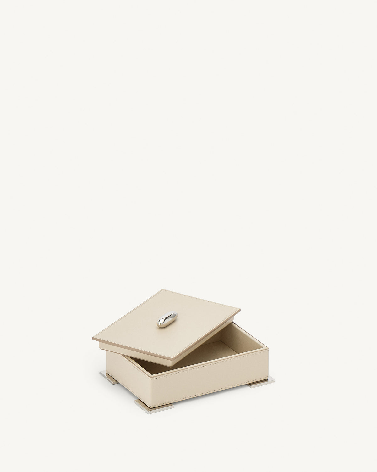 interior view of a parchment beige leather box with silver metal hardware on a white background