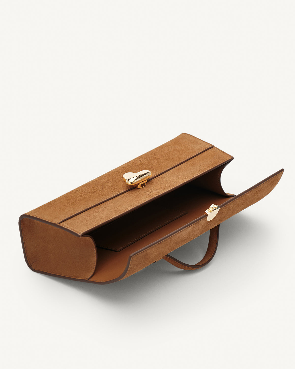 Inside view of Saddle Suede leather handbag with a silver clasp on a white background