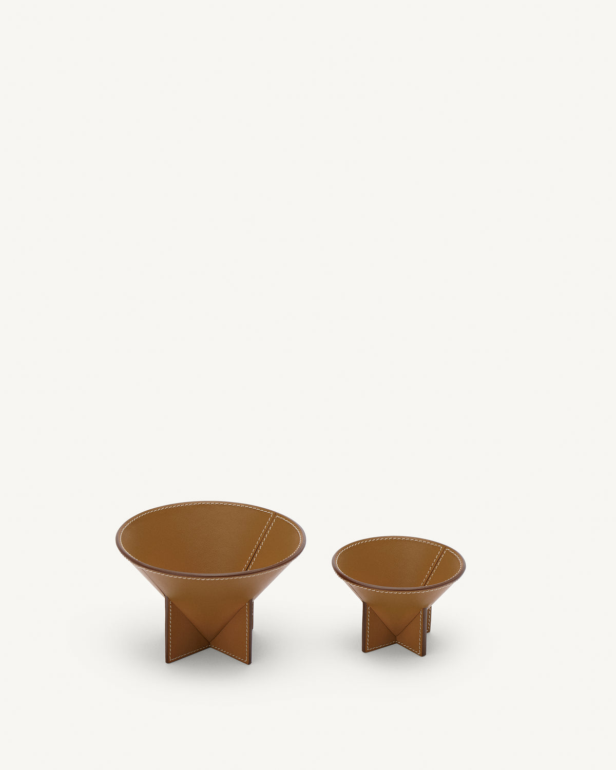 front view of two saddle brown leather dishes on a white background