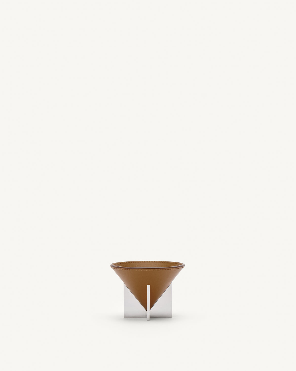 front view of a saddle brown leather dish with silver metal feet on a white background