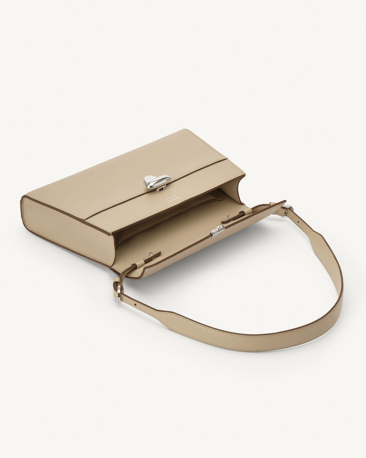 interior view of a bone beige leather bag with a silver clasp on a white background