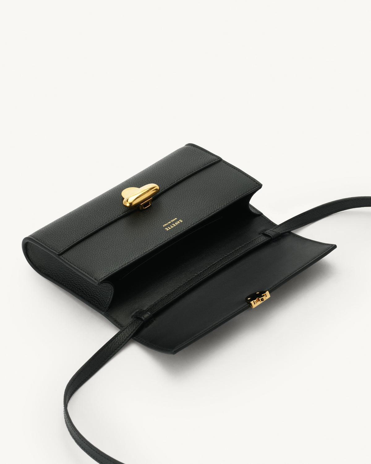 interior view of black bag with gold clasp on a white background