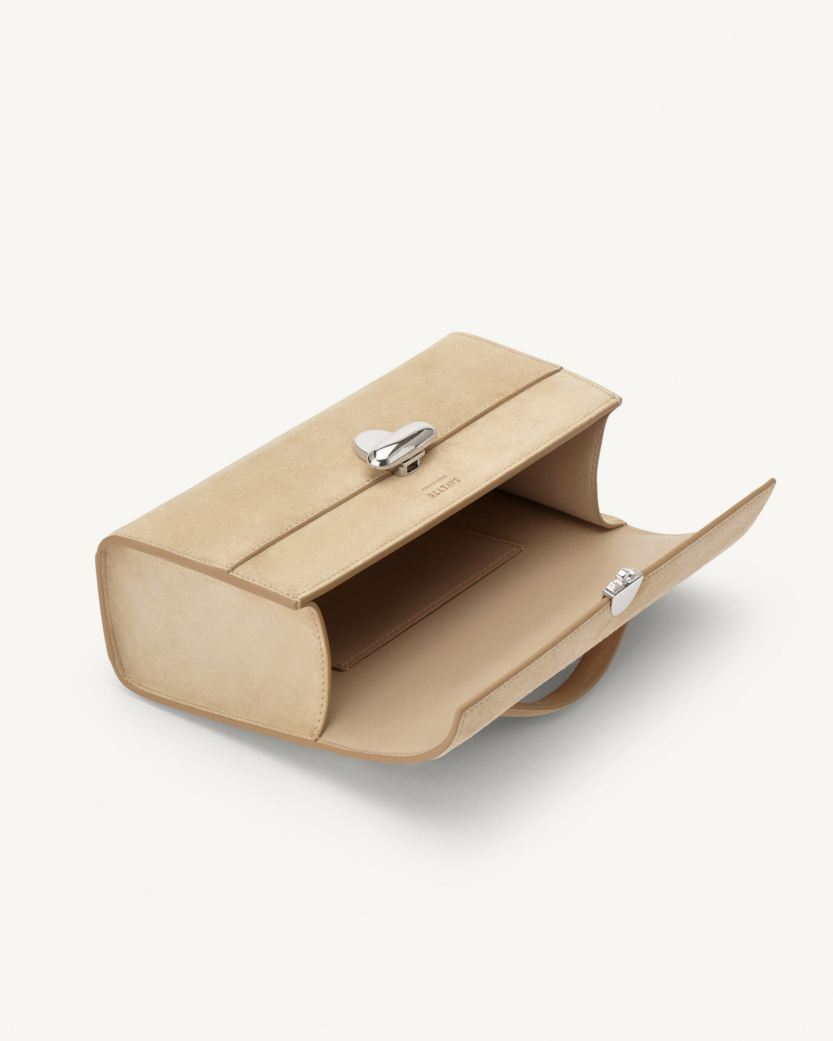 interior view of a flax beige suede bag with a silver clasp on a white background