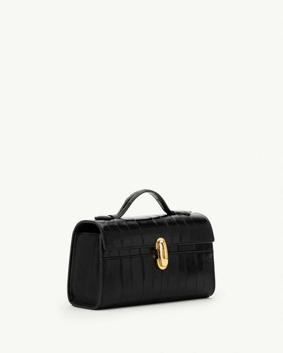 side view of a black eel bag with a gold clasp on a white background
