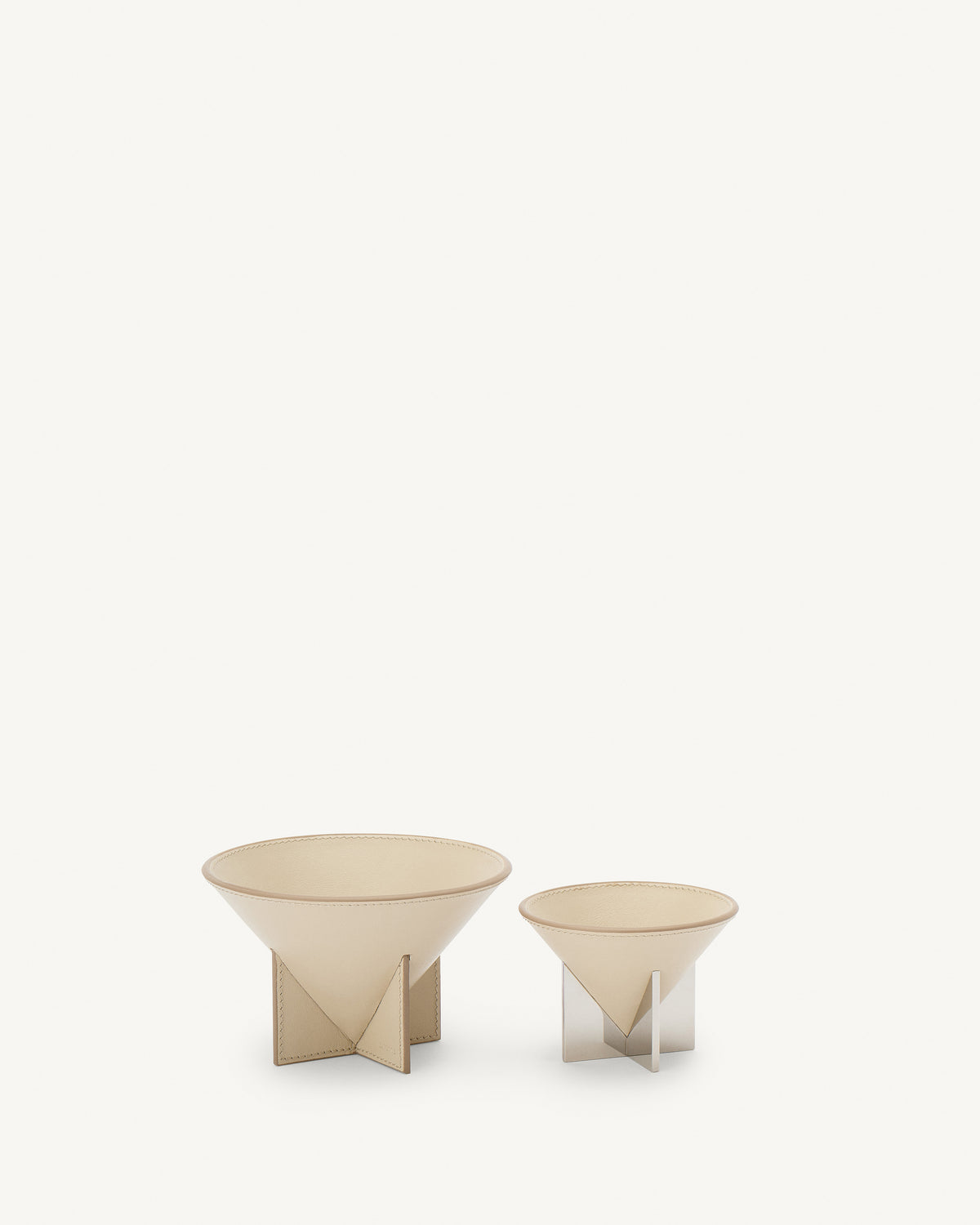 front view of two parchment beige leather dishes on a white background