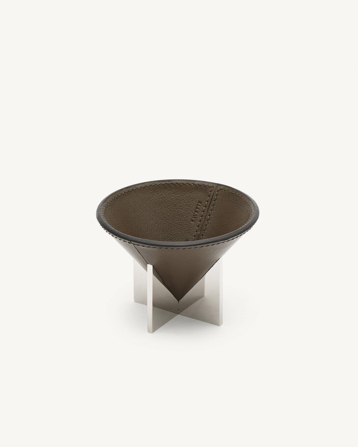 interior view of a mink brown leather dish with silver metal feet on a white background