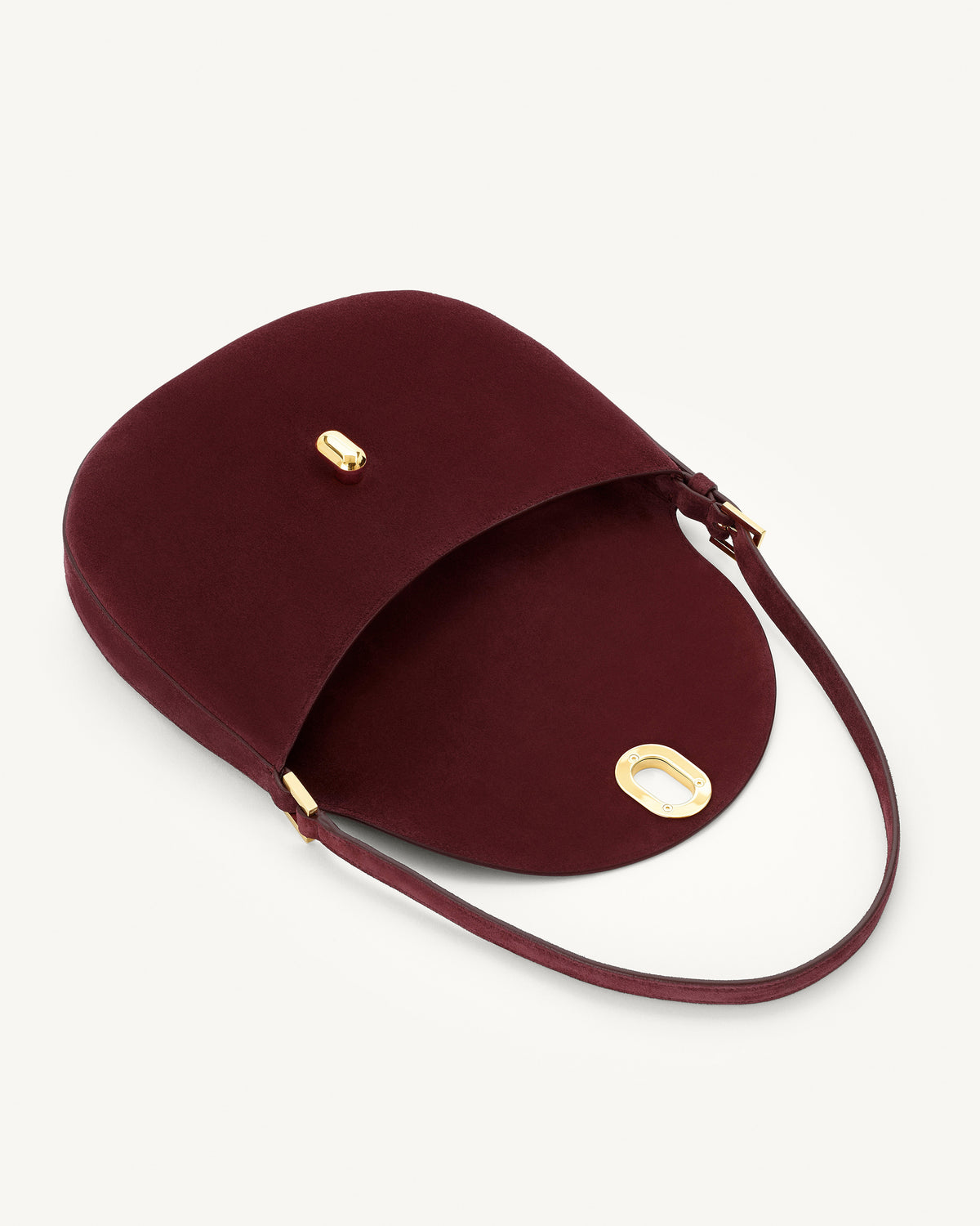 interior view of a plum red suede bag with gold hardware on a white background