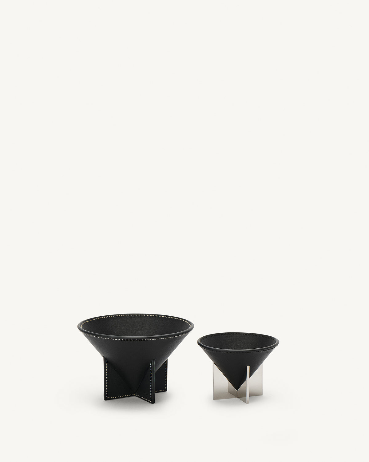 front view of two ebony black leather dishes on a white background