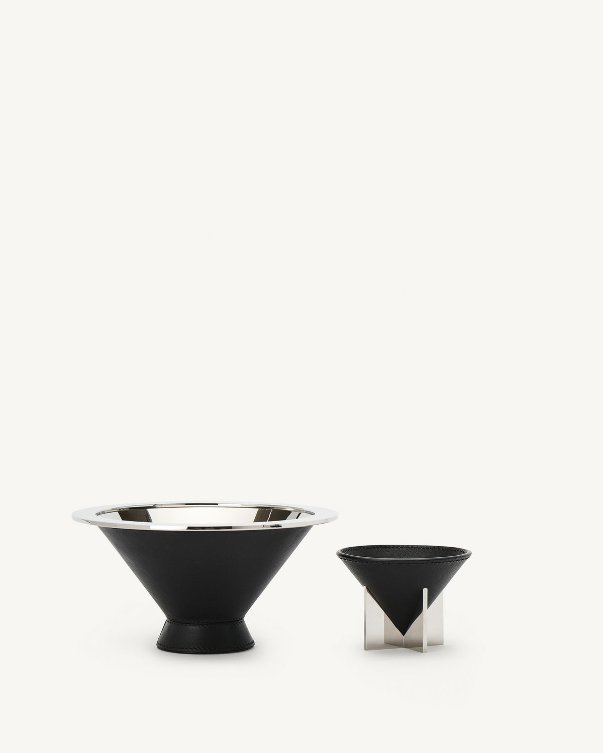 front view of two ebony black leather dishes on a white background