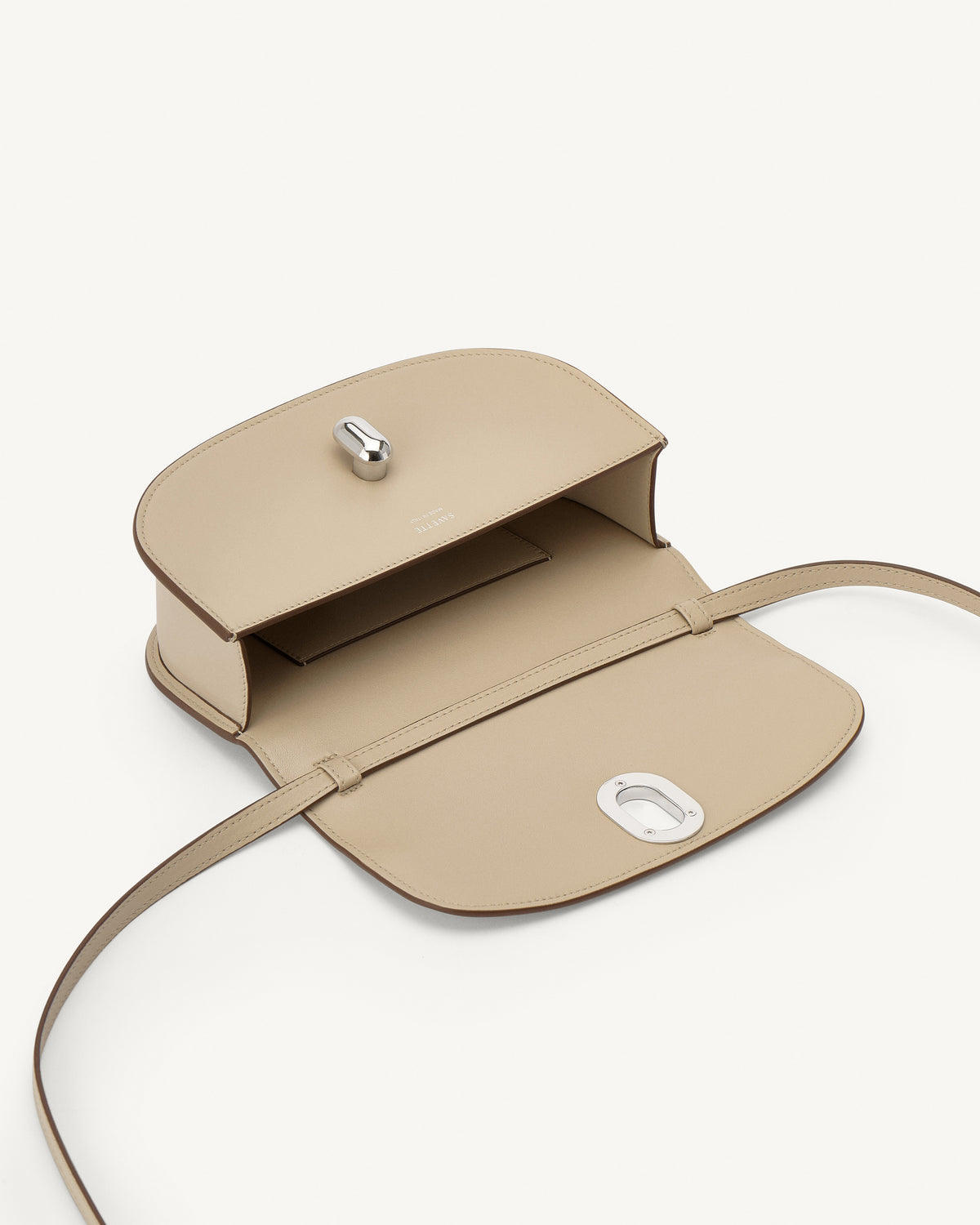 interior view of a bone beige leather bag with silver hardware on a white background