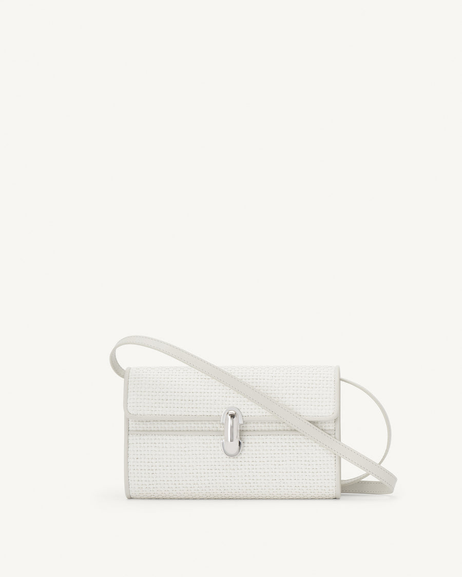 front view of an ivory raffia bag with leather trim with a silver clasp on a white background