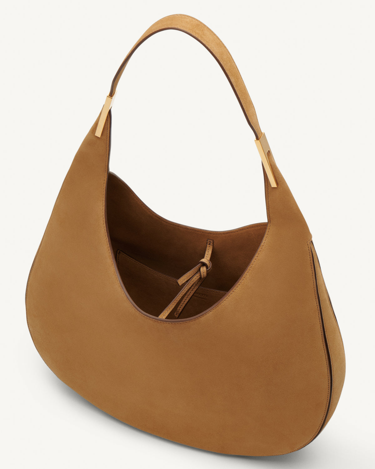 Inside view of saddle suede tote bag with gold hardware on a white background
