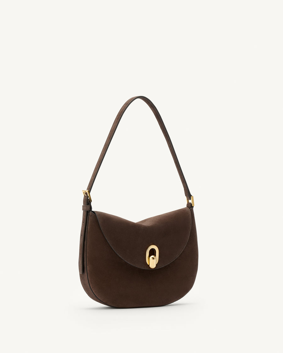 side view of a coffee brown suede shoulder bag with gold hardware on a white background