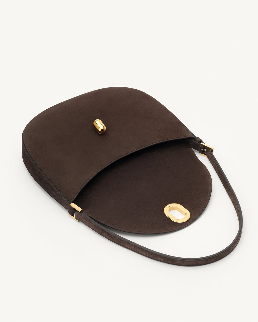 interior view of a coffee brown suede shoulder bag with gold hardware on a white background