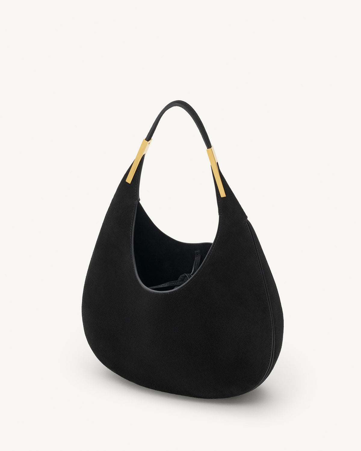 interior view of a black suede bag with gold hardware on a white background