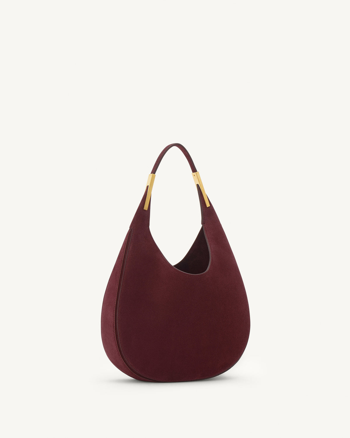 side view of a plum red suede bag with gold hardware on a white background