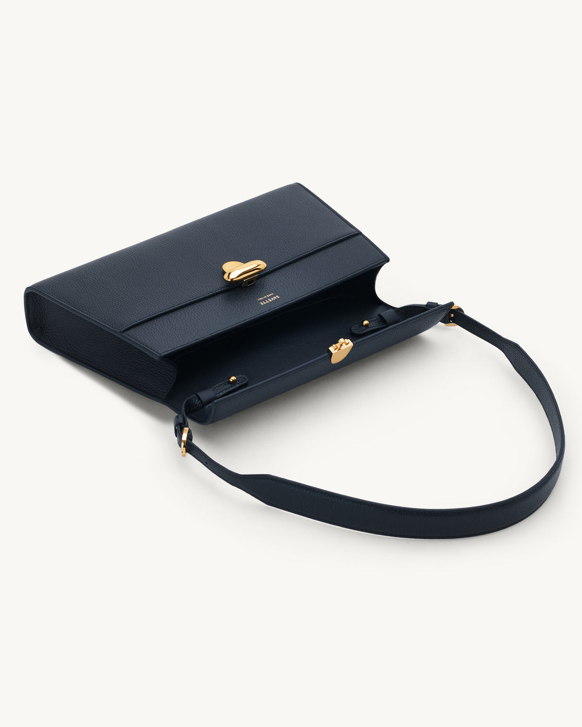 interior view of navy blue bag with gold clasp on a white background