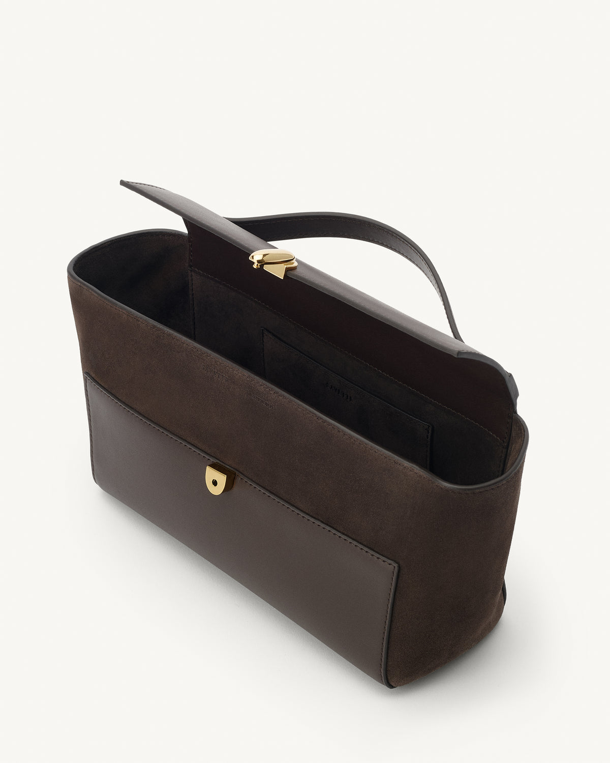 interior view of a coffee brown top handle bag in smooth and suede leather with a gold clasp on a white background 
