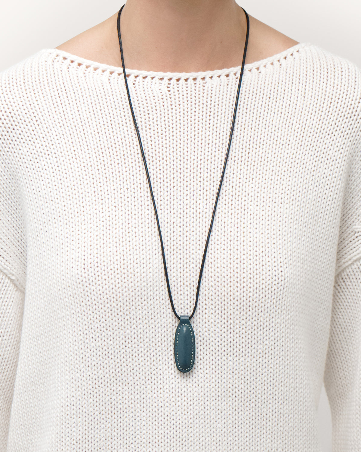 on model view of ocean blue leather pendant on a white background