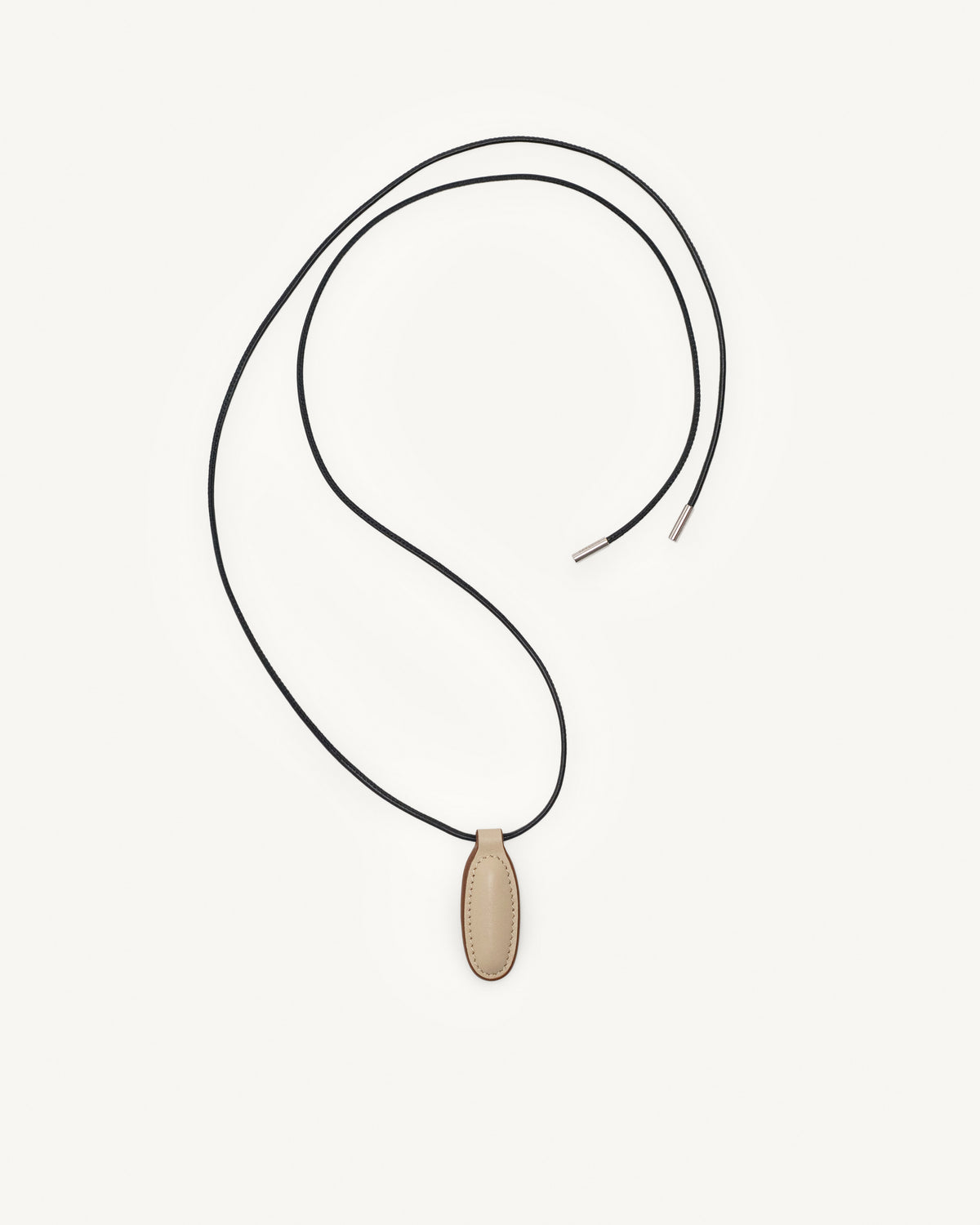 top view of bone beige leather pendant on a white background