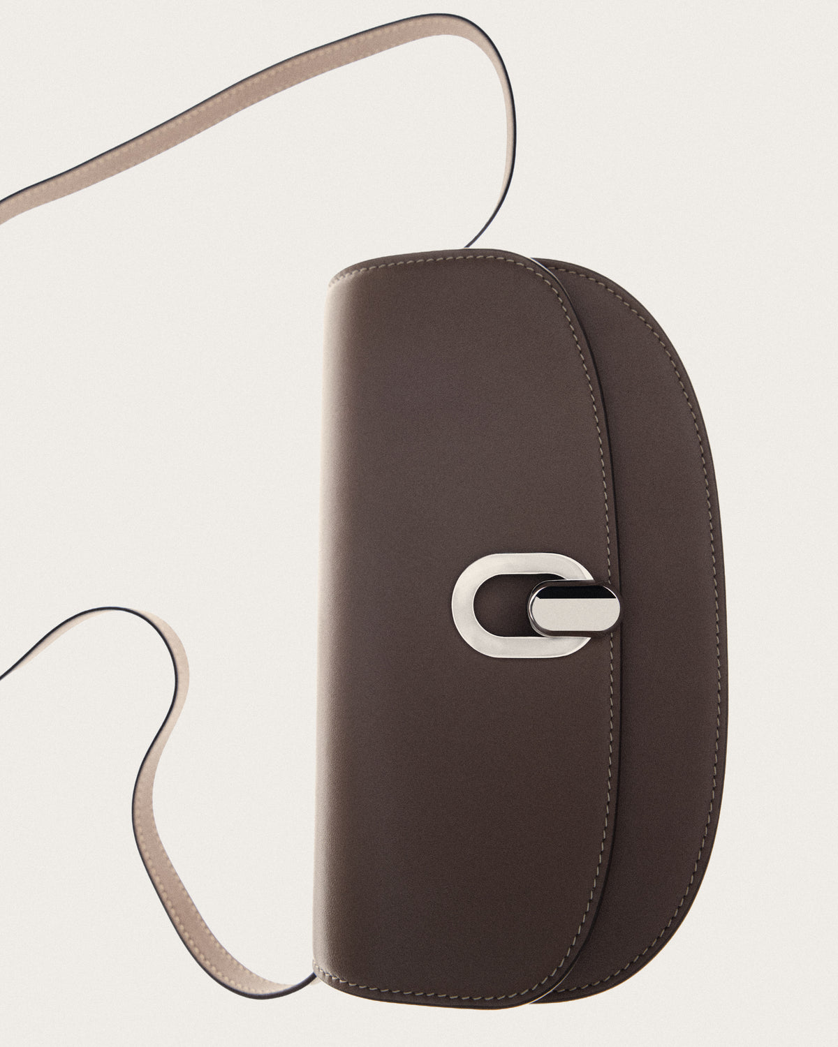 campaign image of a taupe brown leather bag with silver hardware on a white background