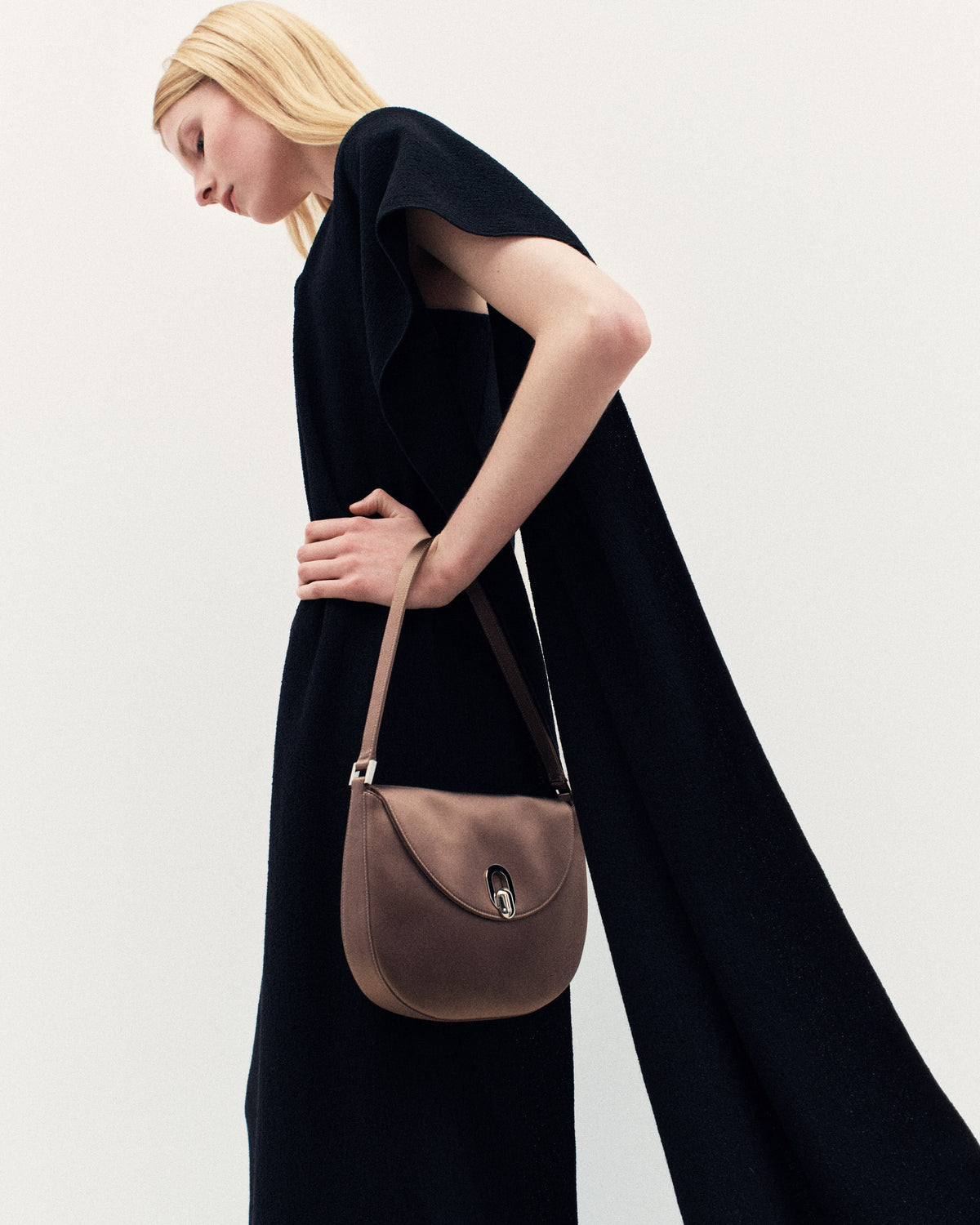 campaign on model image of taupe brown satin bag with silver hardware on a white background