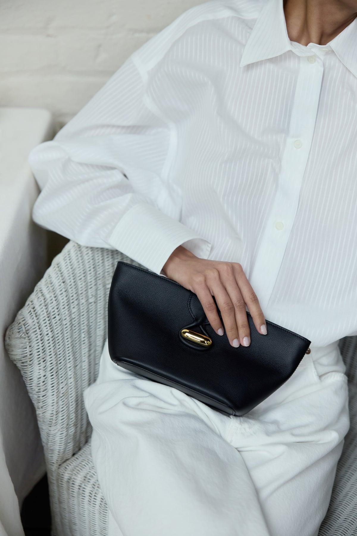 campaign on model image of a black leather pouch with gold hardware