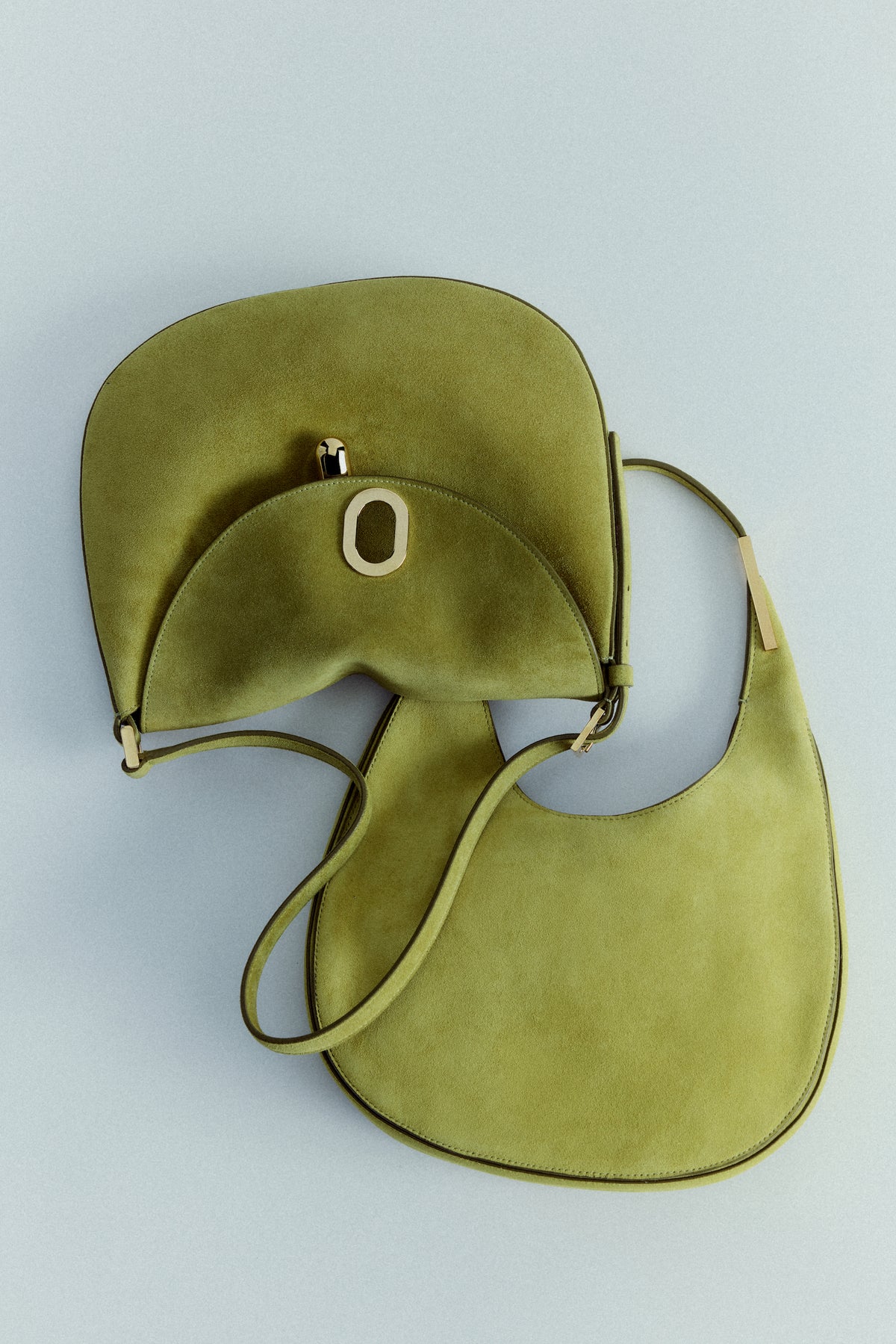 campaign images of two chrtreuse green suede bags with gold hardware on an off white background