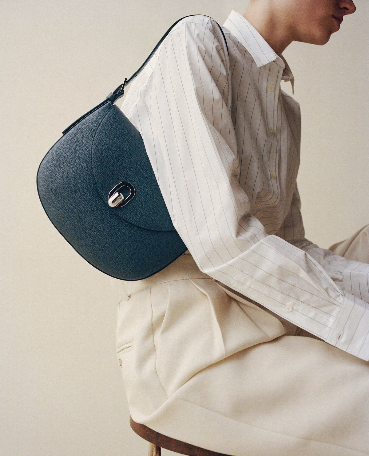 on model view of an ocean blue bag with a silver clasp