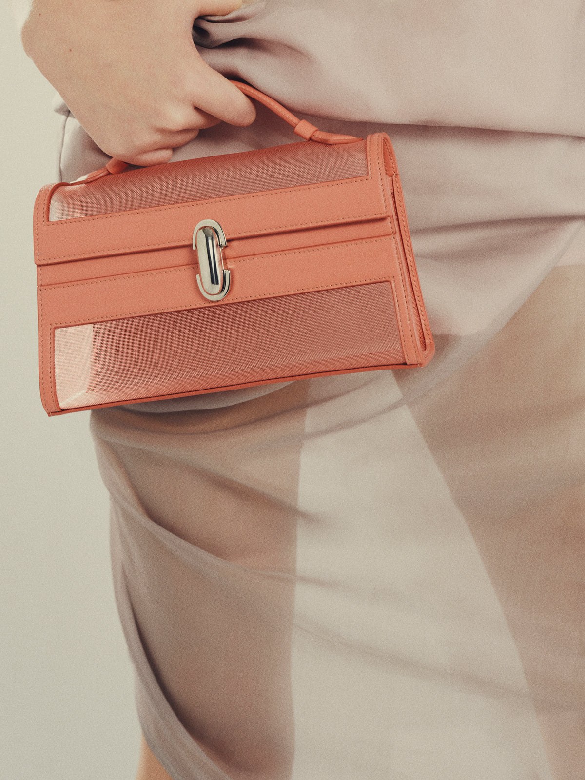 Woman holding pink Symmetry Pochette handbag