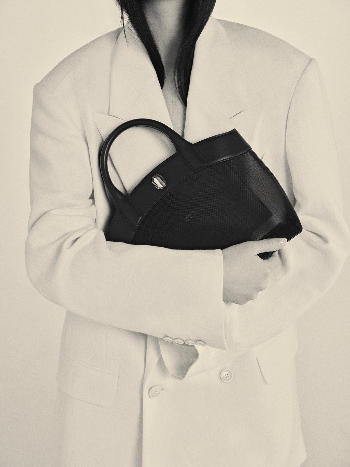 Woman holding black Small Tondo Tote handbag