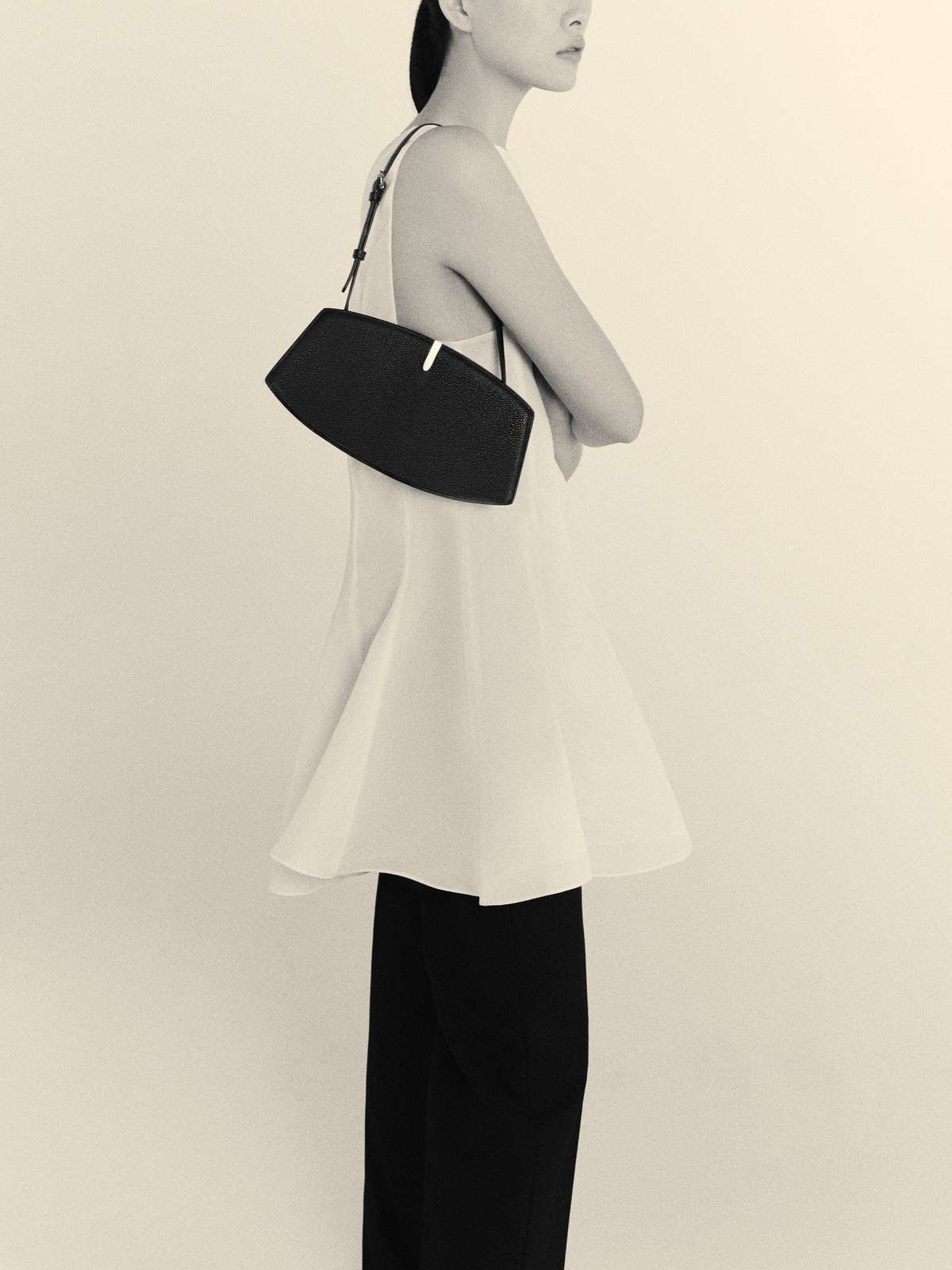 black and white on model image of a black bag with silver hardware on a white background