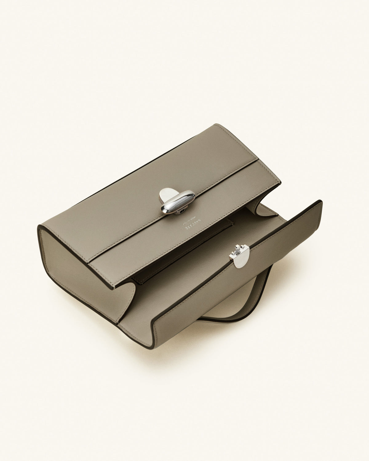 interior view of a clay beige bag with a silver clasp on a white background