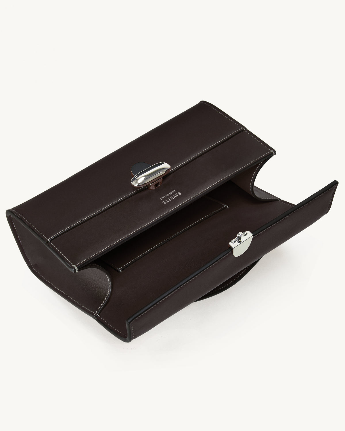 interior view of a currant brown bag with silver clasp on a white background
