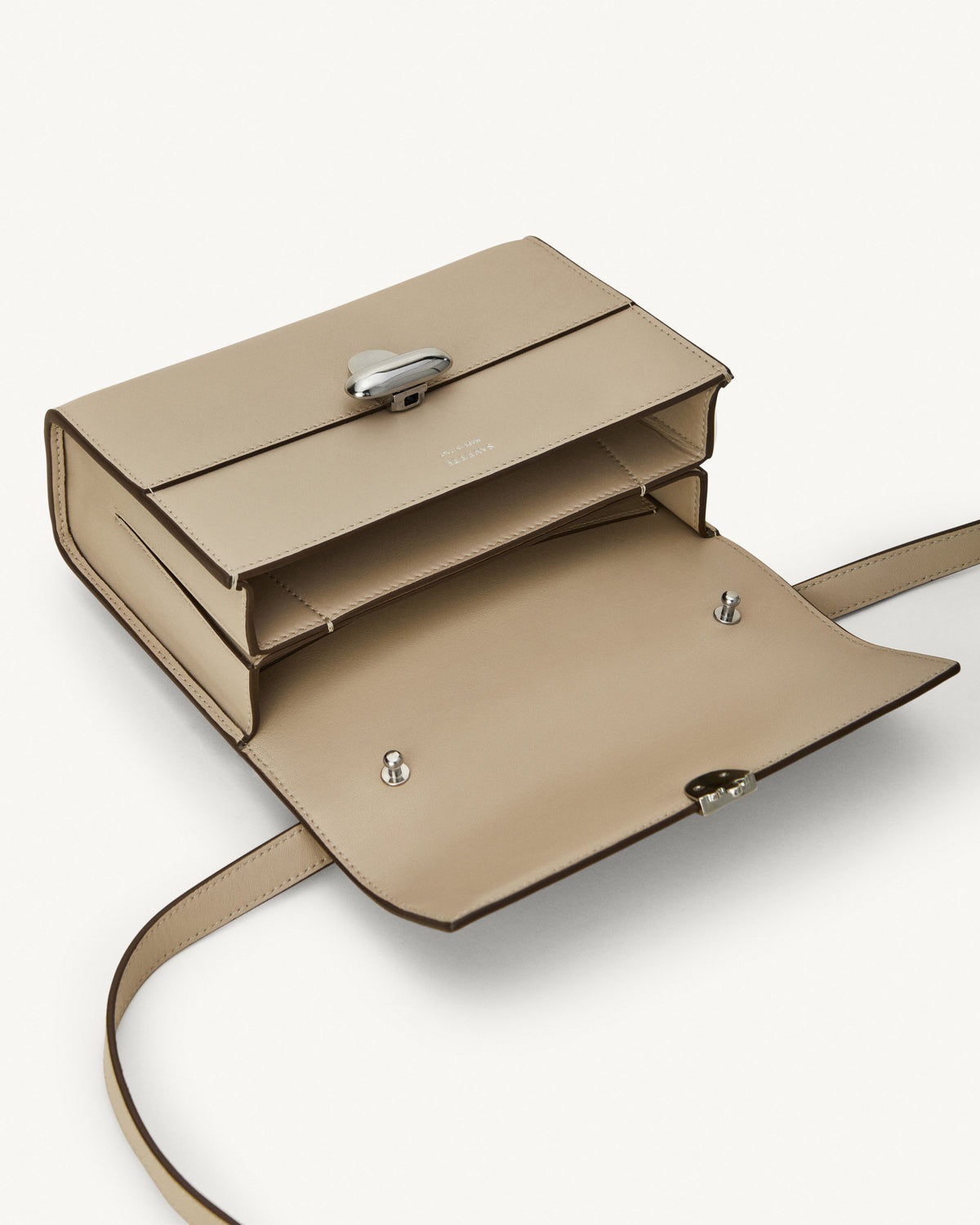 interior view of bone beige bag with silver clasp on a white background