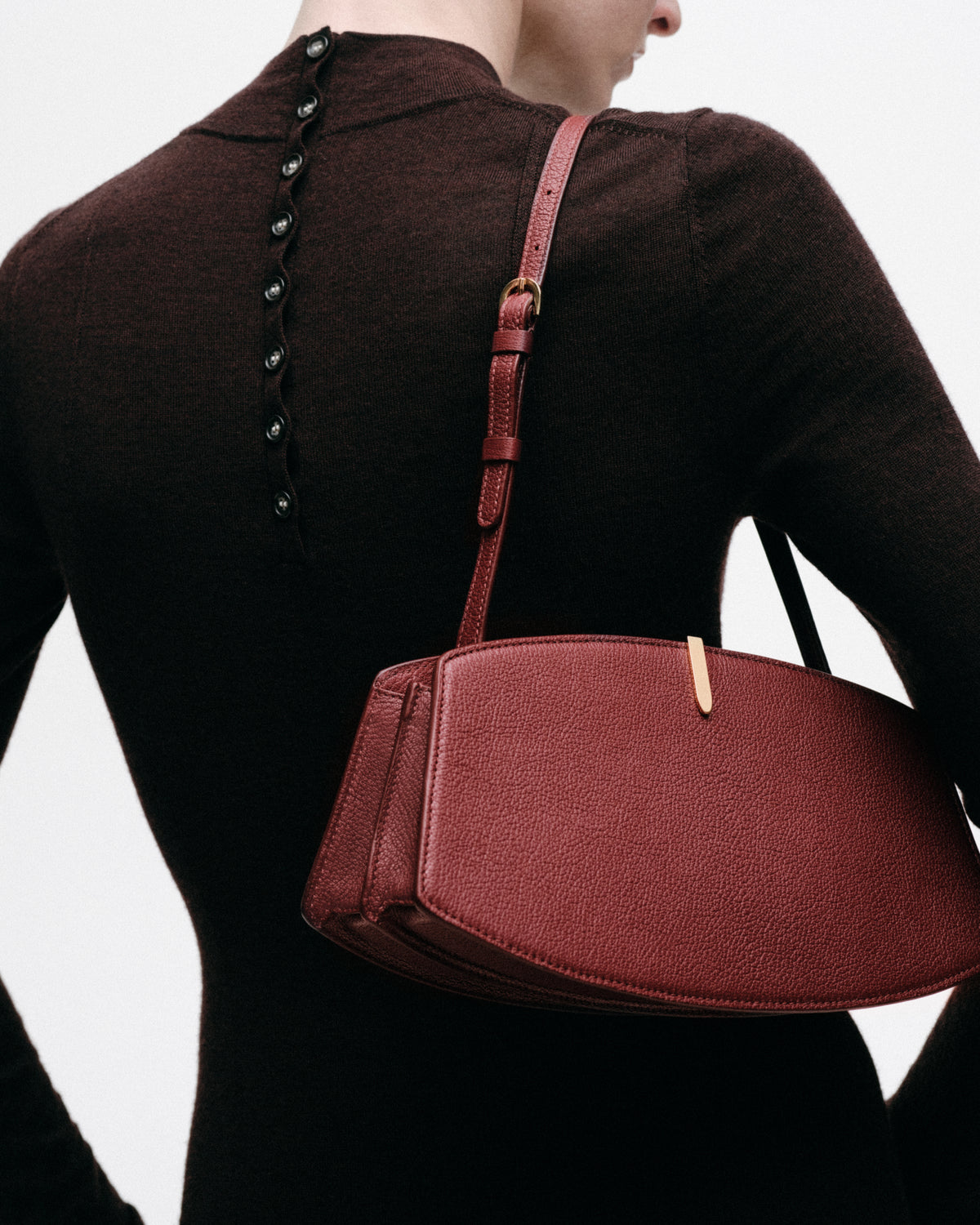 on model image of a red bag with a gold clasp on a red background