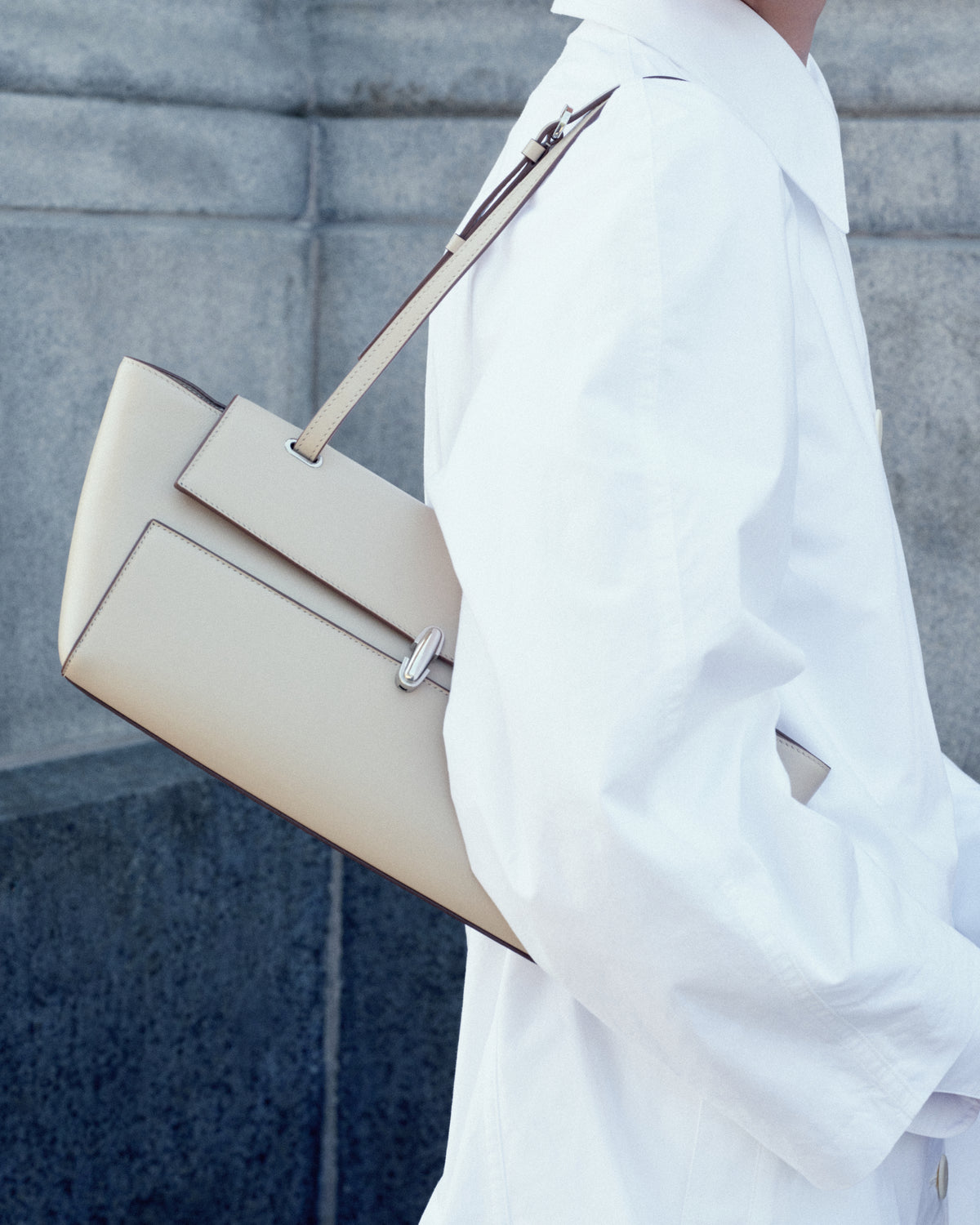 campaign on model image of a bone beige leather bag with silver clasp