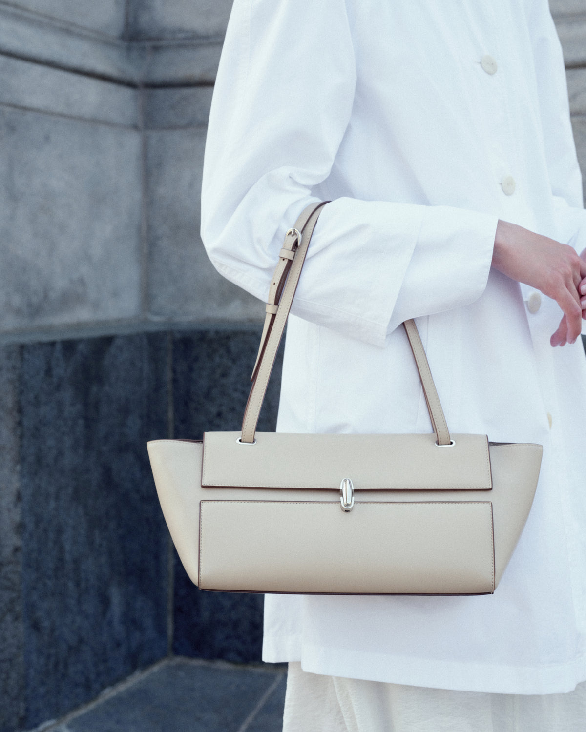 campaign on model image of a bone beige leather bag with silver clasp