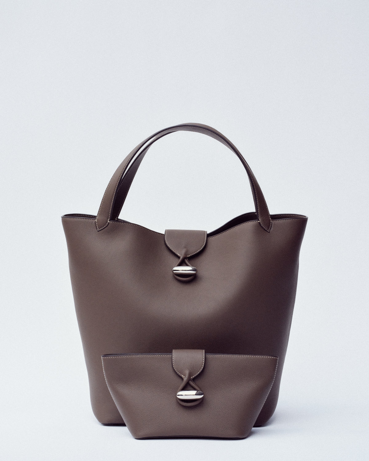 campaign image of two mink brown leather bags with silver clasps on a white background