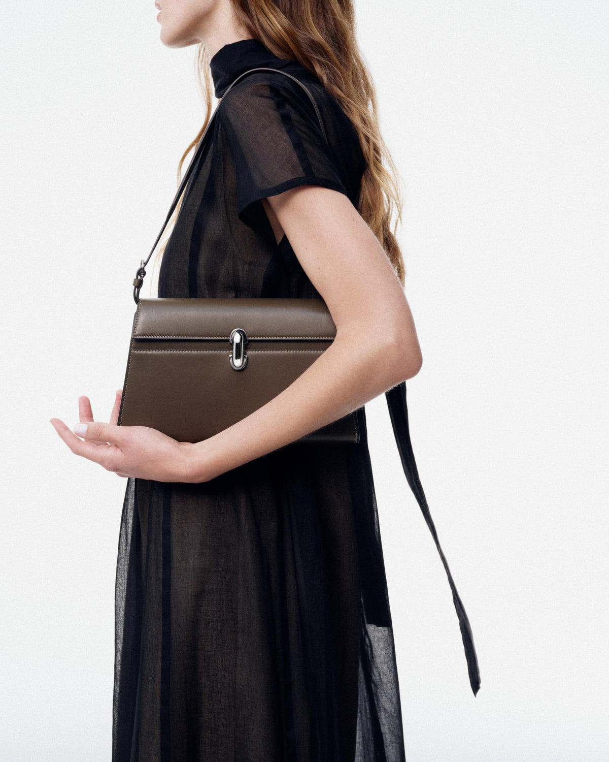 on model image of mink brown bag with silver clasp on a white background