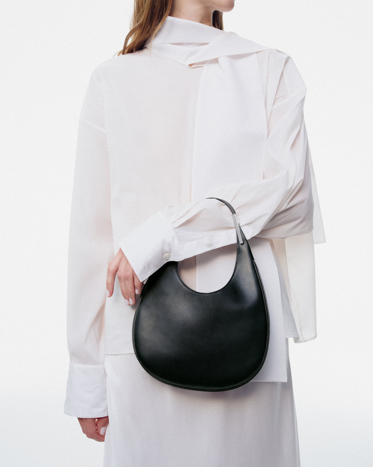 on model image of black leather bag with silver hardware on a white background