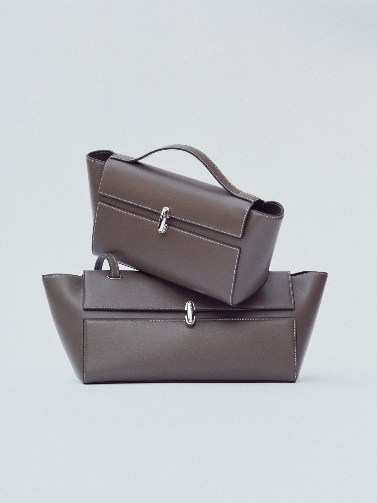 campaign image of two mink brown leather bags with silver clasps on a white background