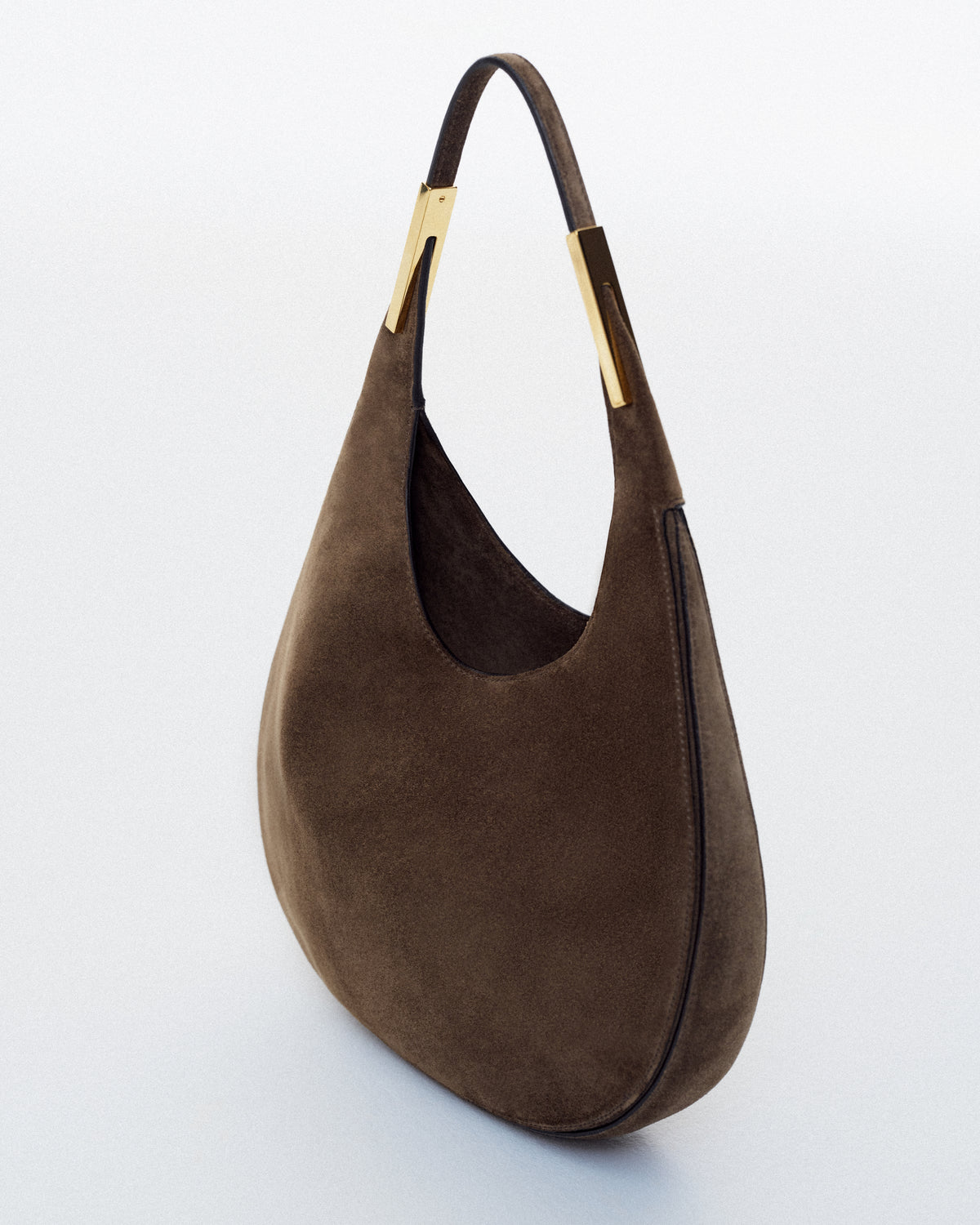 side view of brown suede bag with gold hardware on a white background