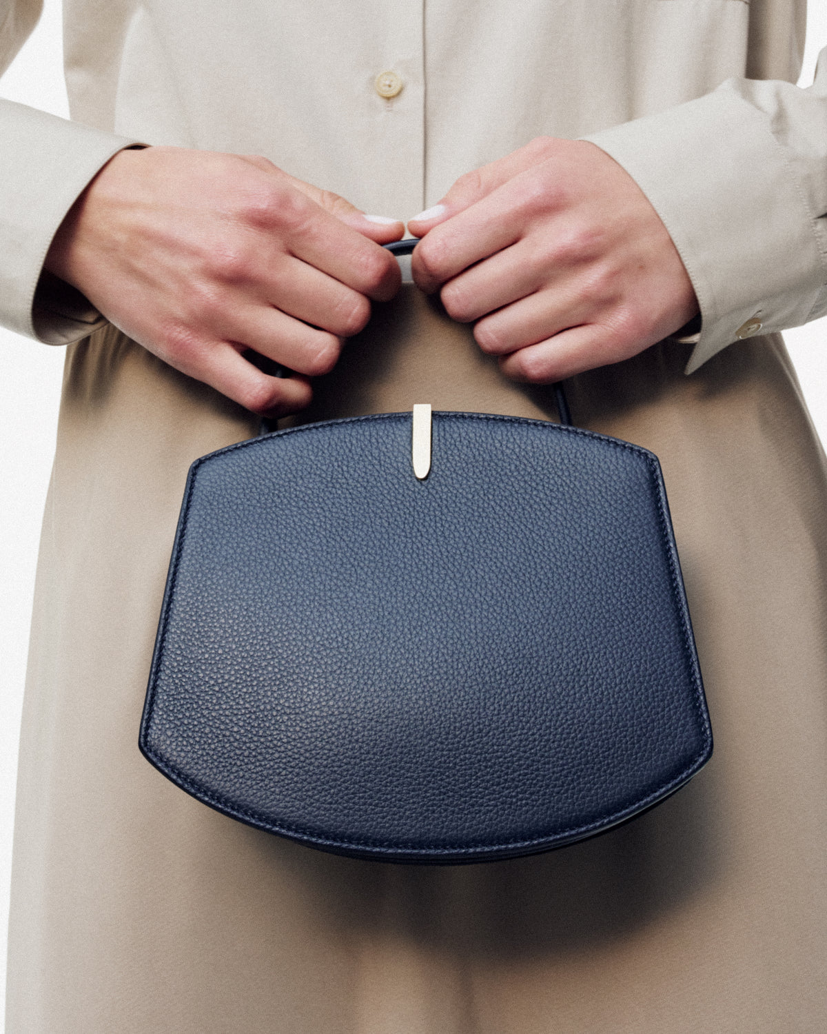 on model image of a black leather bag with a gold clasp