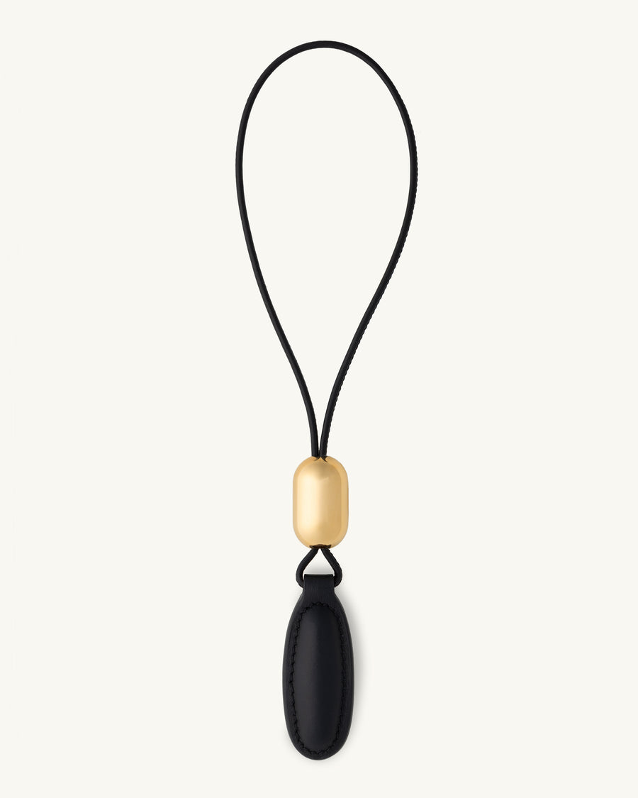 front view of a black leather charm on a white background