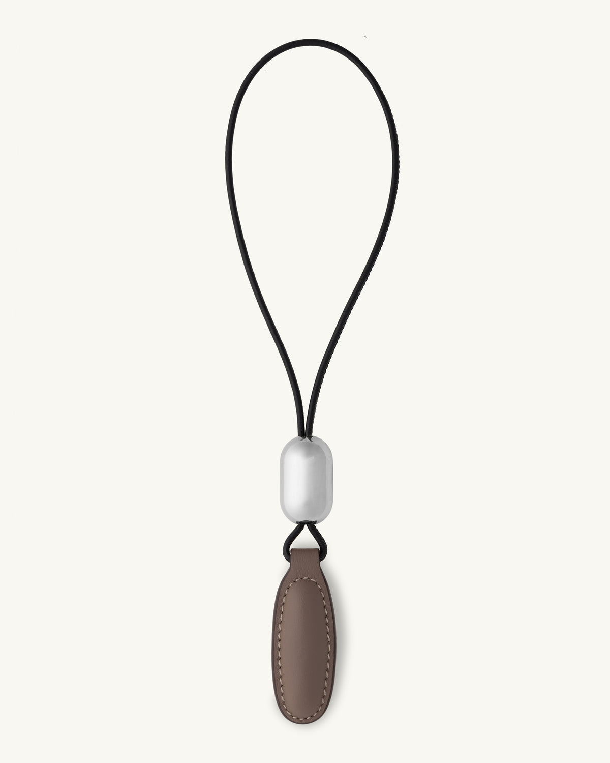 front view of a taupe brown leather charm on a white background